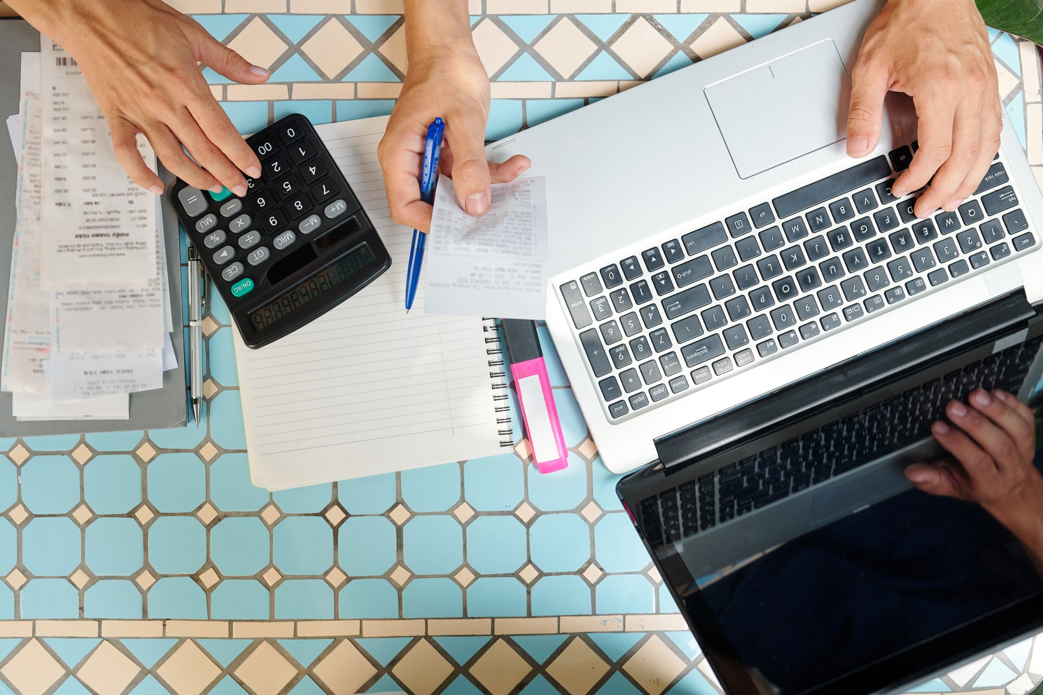 Calculator, laptop and receipts laid out on a table