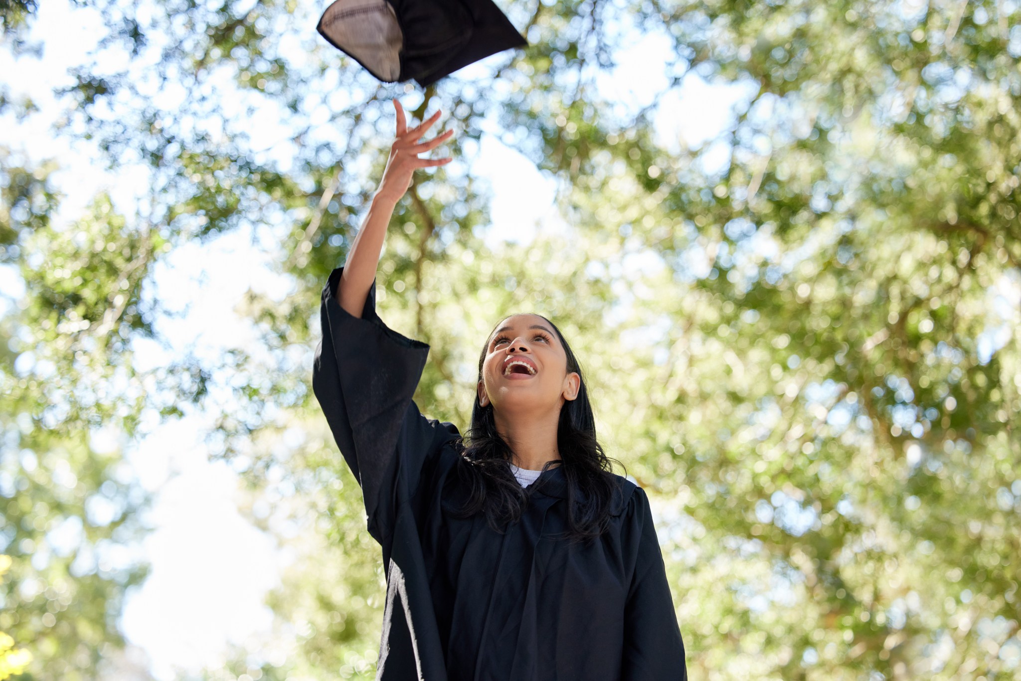 Graduate tossing cap in the air at a celebration